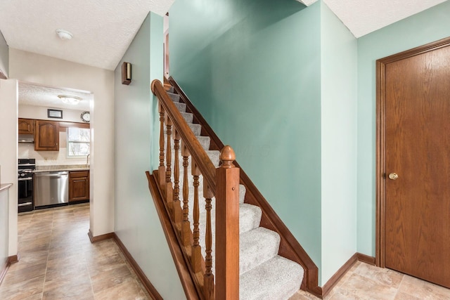 stairs with a textured ceiling