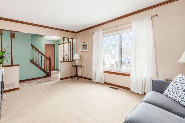 living area with a textured ceiling, light colored carpet, and ornamental molding