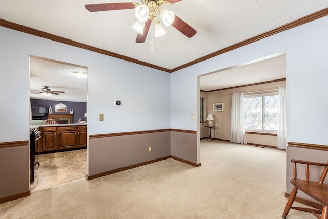 unfurnished room featuring light colored carpet, a textured ceiling, and ornamental molding