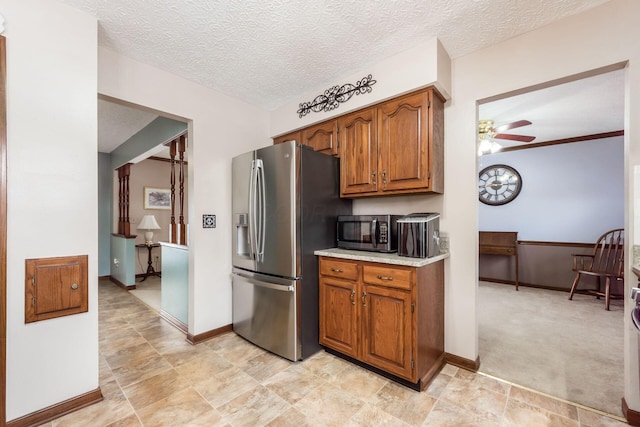 kitchen with light carpet, a textured ceiling, ceiling fan, and appliances with stainless steel finishes