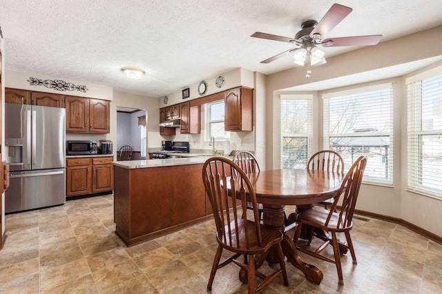 dining room featuring sink, a textured ceiling, and ceiling fan