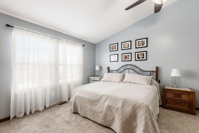 carpeted bedroom with ceiling fan and vaulted ceiling