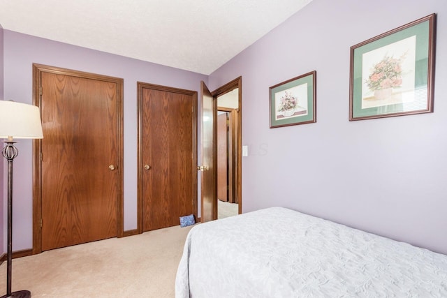 carpeted bedroom featuring multiple closets