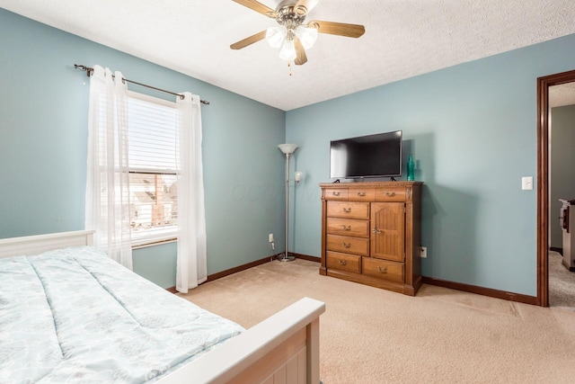 carpeted bedroom featuring ceiling fan, multiple windows, and a textured ceiling