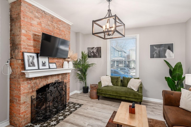 living room featuring a fireplace, light hardwood / wood-style floors, and a notable chandelier