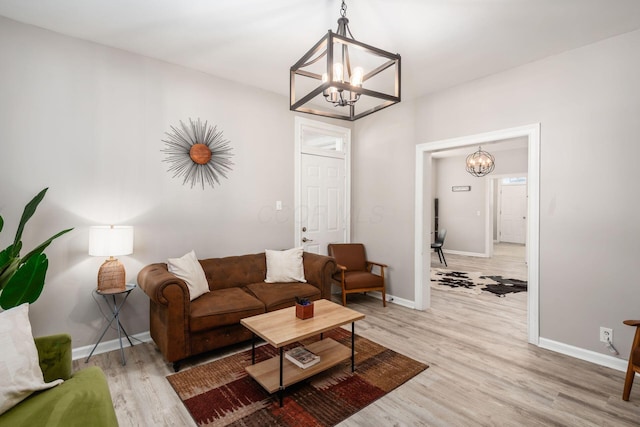 living room with an inviting chandelier and light hardwood / wood-style floors