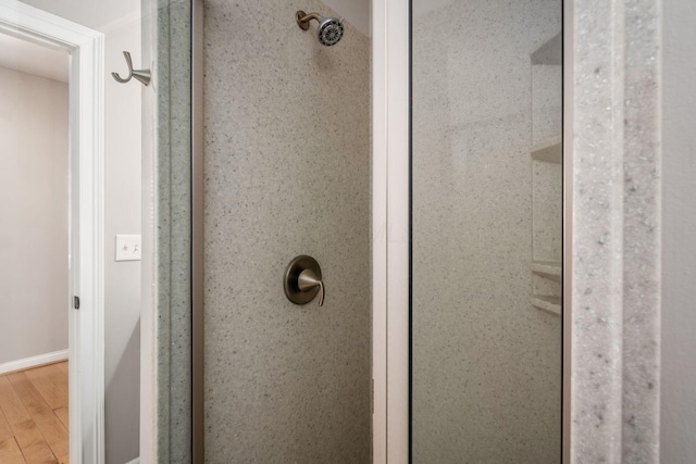 bathroom featuring hardwood / wood-style floors and tiled shower