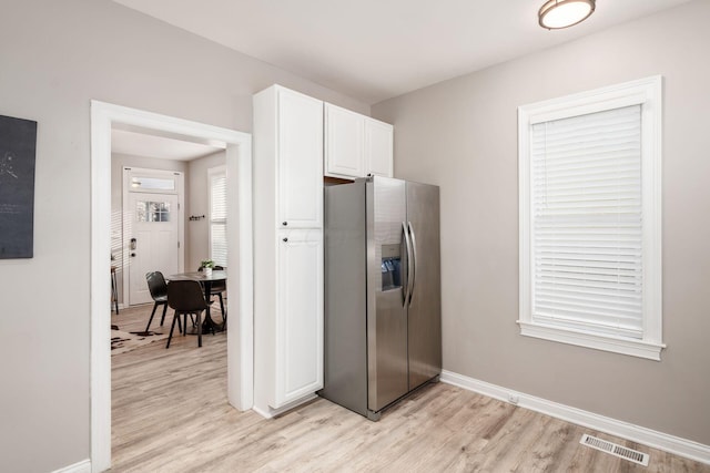 kitchen with white cabinetry, stainless steel fridge with ice dispenser, and light hardwood / wood-style floors