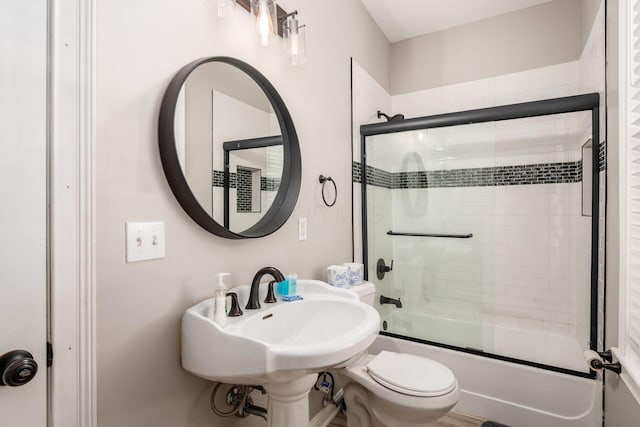 full bathroom featuring sink, toilet, and combined bath / shower with glass door