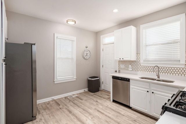 kitchen featuring white cabinetry, appliances with stainless steel finishes, sink, and decorative backsplash