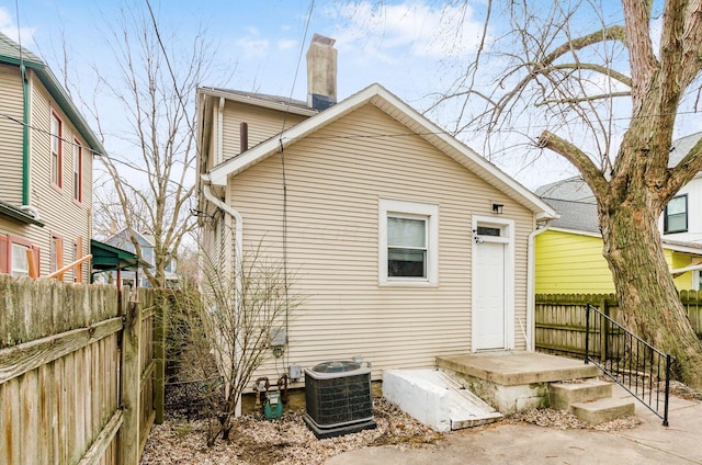 1017 Michigan Ave, Columbus, OH 43201 - rear view of property with central AC unit, a chimney, and fence