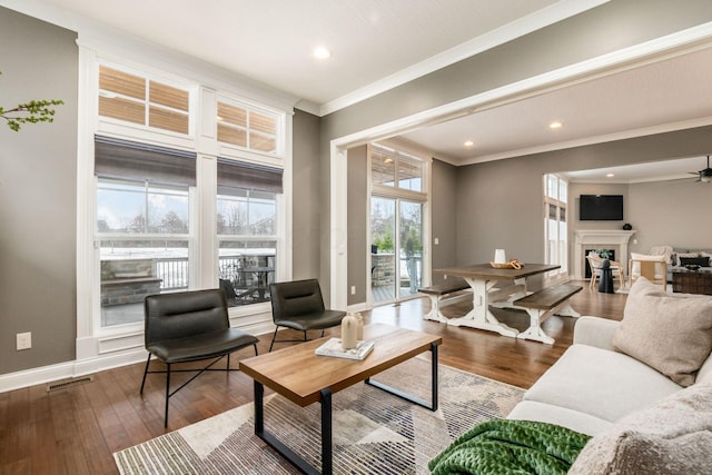 living room featuring hardwood / wood-style flooring, ornamental molding, and ceiling fan