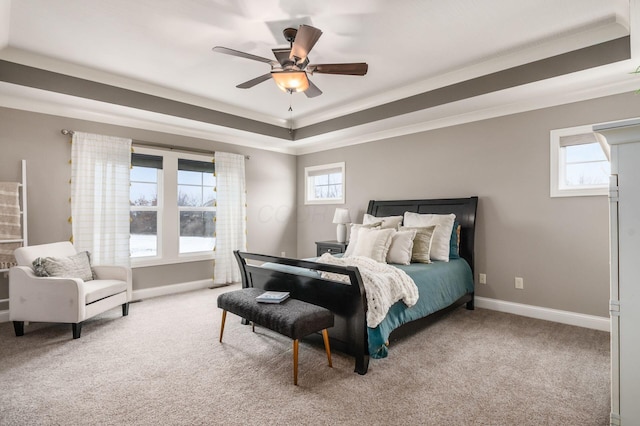 carpeted bedroom with crown molding, ceiling fan, a raised ceiling, and multiple windows