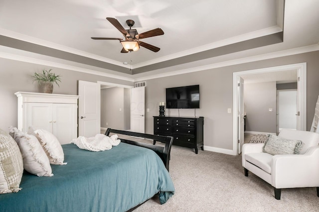 bedroom with crown molding, ceiling fan, a raised ceiling, and light carpet