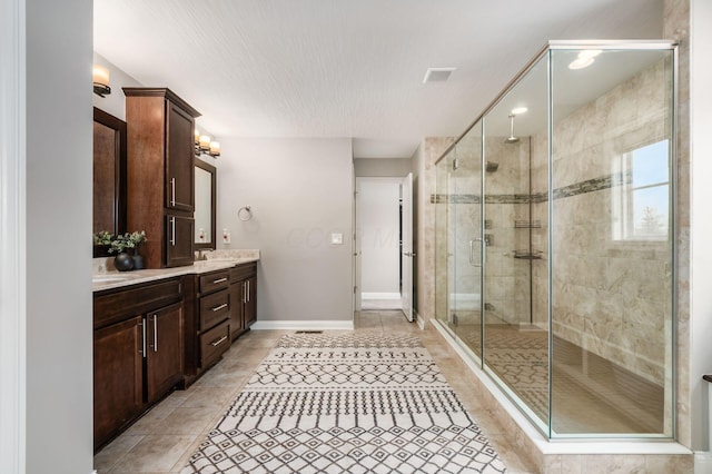 bathroom with vanity, a shower with shower door, and tile patterned floors