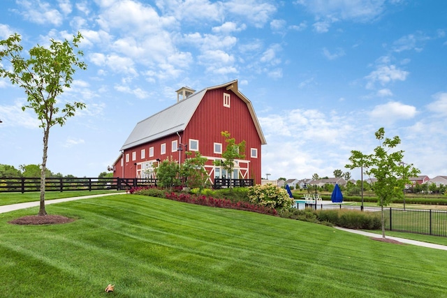 view of property's community featuring a yard and an outdoor structure