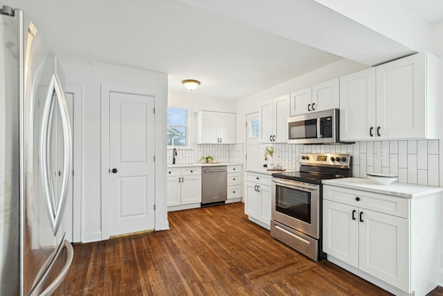 kitchen featuring stainless steel appliances, dark hardwood / wood-style flooring, decorative backsplash, and white cabinets