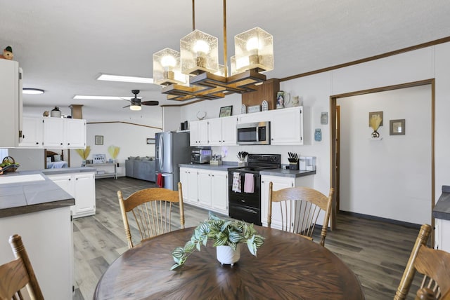 dining area with a skylight, wood-type flooring, sink, ornamental molding, and ceiling fan