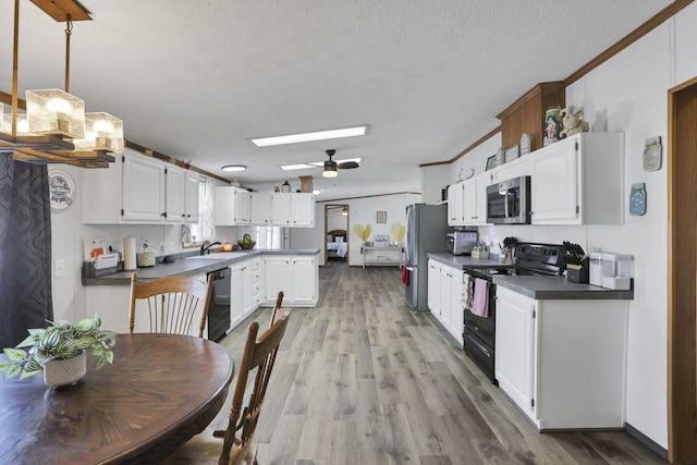 kitchen with crown molding, white cabinets, hardwood / wood-style floors, and black appliances