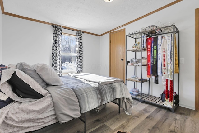 bedroom featuring ornamental molding, dark hardwood / wood-style floors, and a textured ceiling