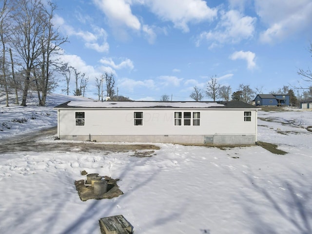 view of snow covered back of property