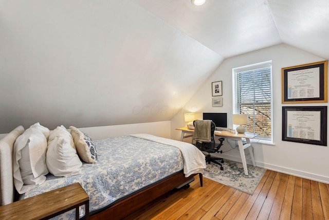 bedroom with lofted ceiling and wood-type flooring