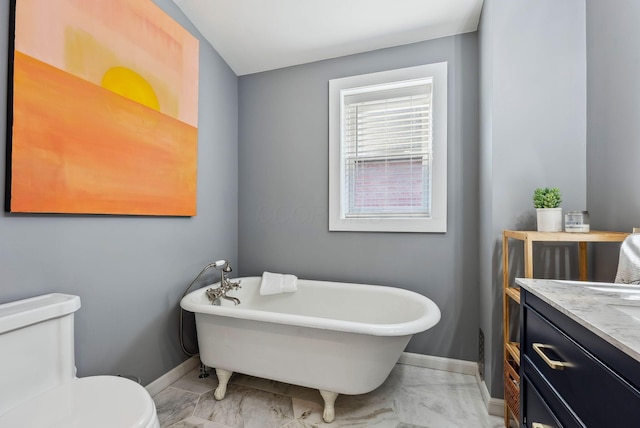 bathroom featuring vanity, a washtub, and toilet