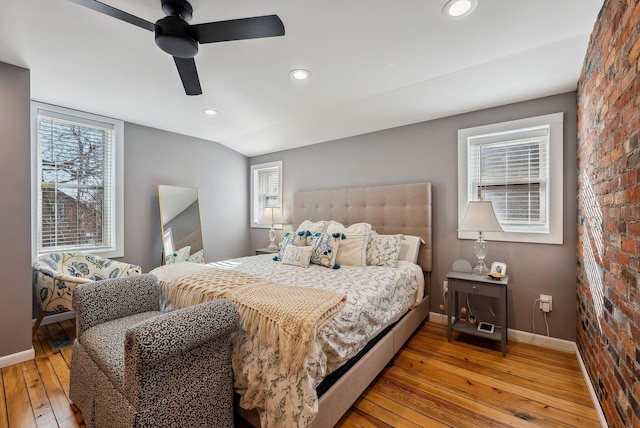 bedroom with brick wall, lofted ceiling, light wood-type flooring, and ceiling fan