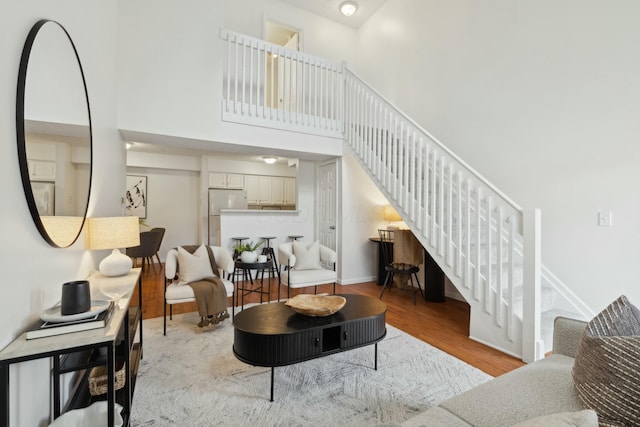 living room with light hardwood / wood-style flooring and a high ceiling