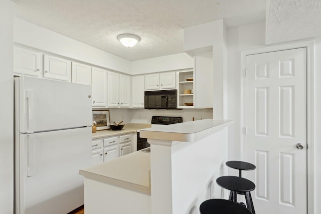 kitchen featuring a kitchen bar, white cabinetry, white refrigerator, kitchen peninsula, and range with electric cooktop