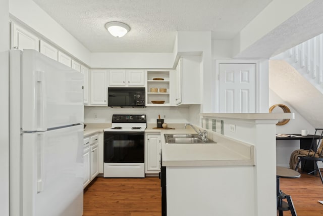 kitchen featuring white cabinetry, wood-type flooring, sink, and white appliances