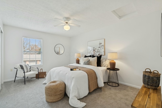 carpeted bedroom with ceiling fan and a textured ceiling