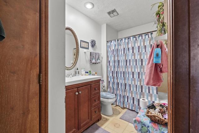 full bathroom with a textured ceiling, tile patterned flooring, vanity, shower / tub combo, and toilet