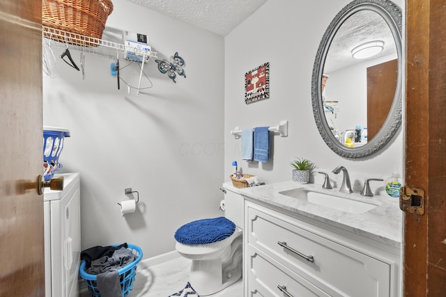 bathroom with a textured ceiling, toilet, and vanity