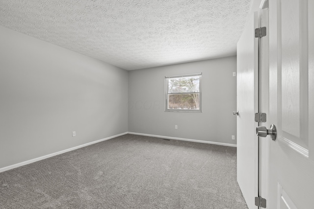 empty room featuring a textured ceiling and carpet flooring