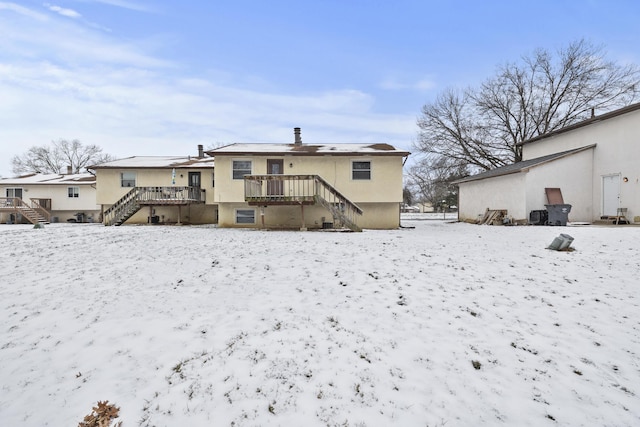 snow covered house with a deck