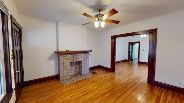 living room with a tiled fireplace, hardwood / wood-style floors, and ceiling fan