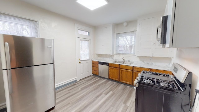 kitchen featuring stainless steel appliances, sink, and light wood-type flooring