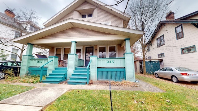 bungalow-style home featuring a front lawn and covered porch