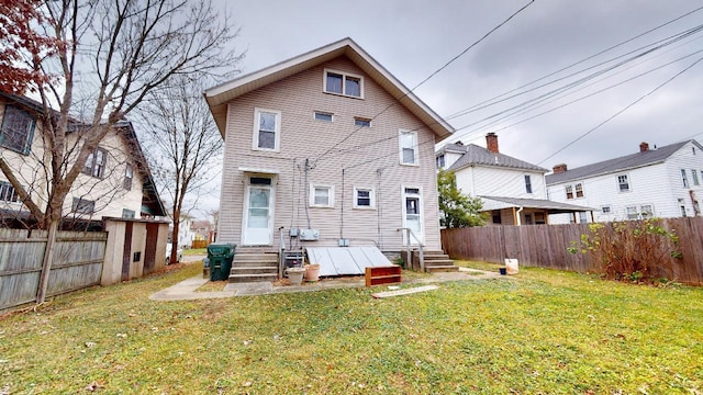 rear view of house featuring a lawn