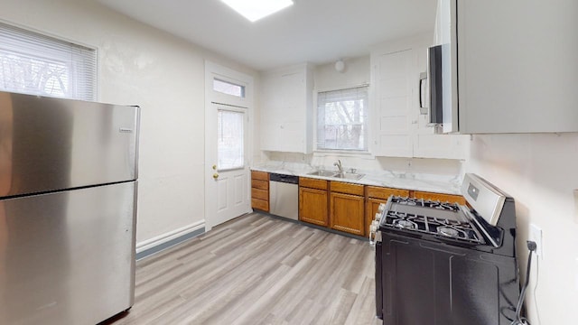 kitchen with sink, light hardwood / wood-style flooring, and appliances with stainless steel finishes