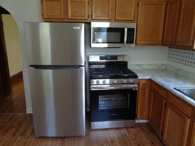 kitchen with dark hardwood / wood-style flooring and stainless steel appliances