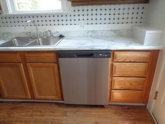 kitchen featuring dishwasher, sink, and light hardwood / wood-style floors