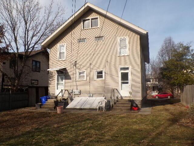 back of property featuring a lawn