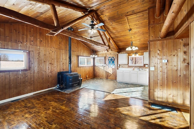 interior space featuring wood ceiling, wooden walls, a wood stove, high vaulted ceiling, and beam ceiling