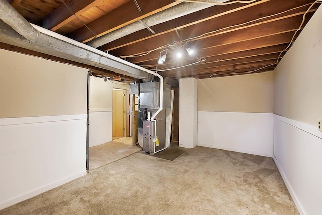 basement featuring heating unit and carpet