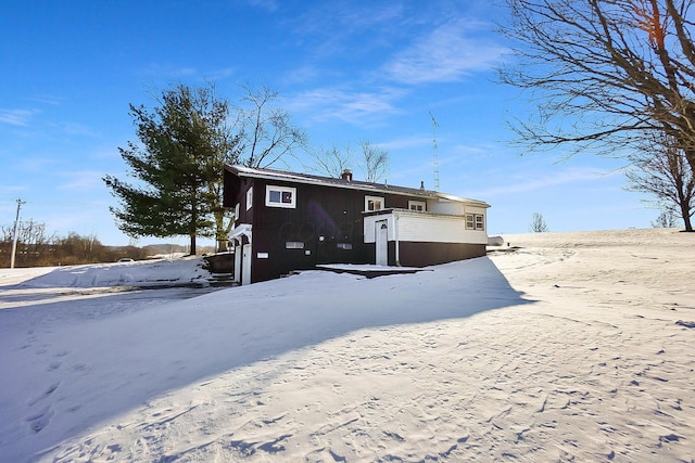 view of snow covered rear of property