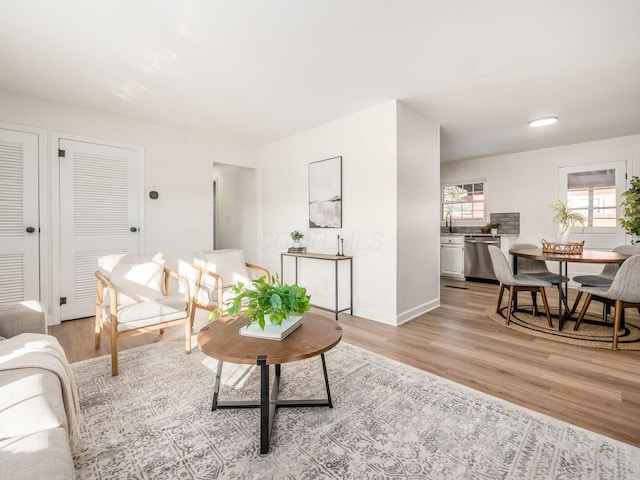 living room with light hardwood / wood-style floors and sink