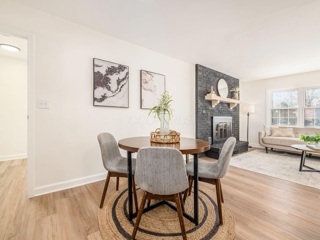 dining area featuring a fireplace and light hardwood / wood-style floors