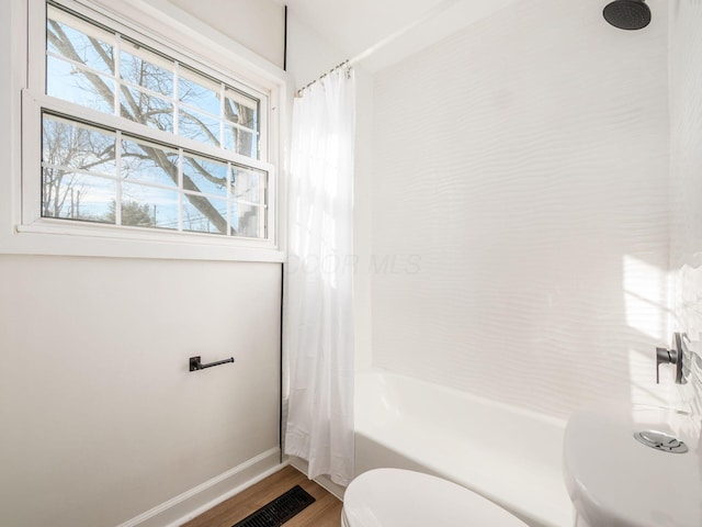 bathroom with wood-type flooring, toilet, and shower / bath combination with curtain